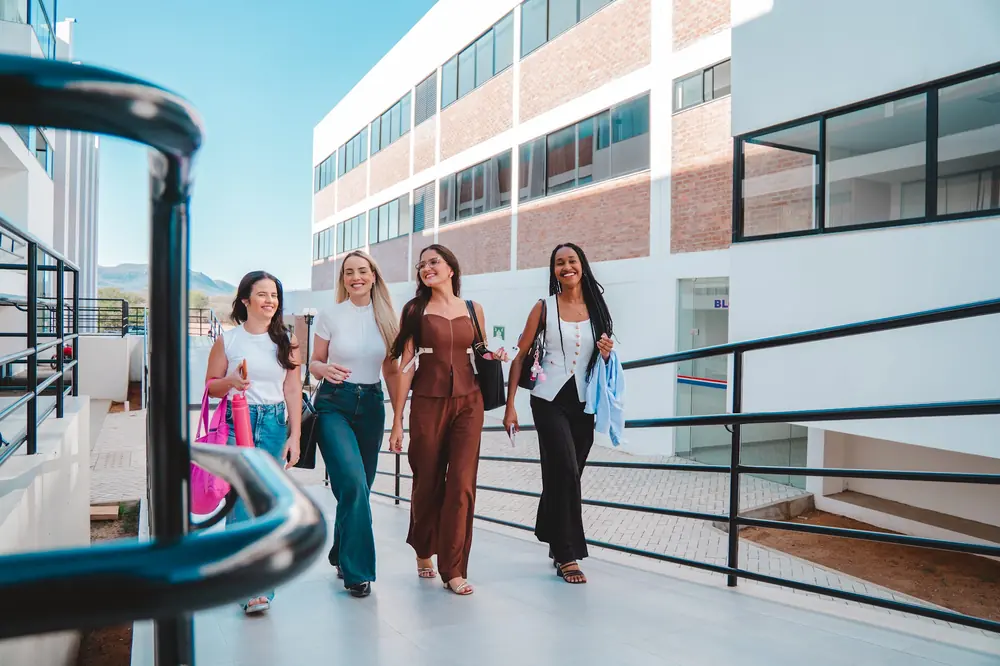 Quatro alunas caminhando juntas pelo campus da UNIFIS