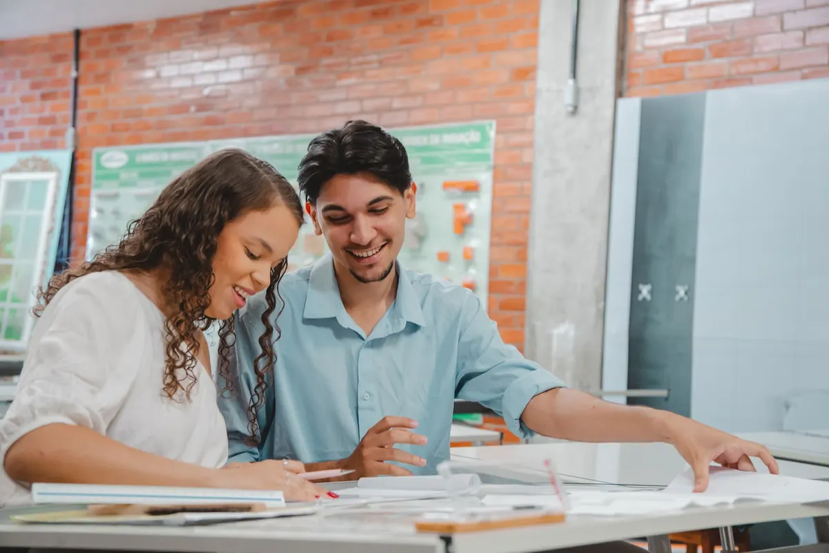 Dois alunos estudando juntos em uma mesa da UNIFIS